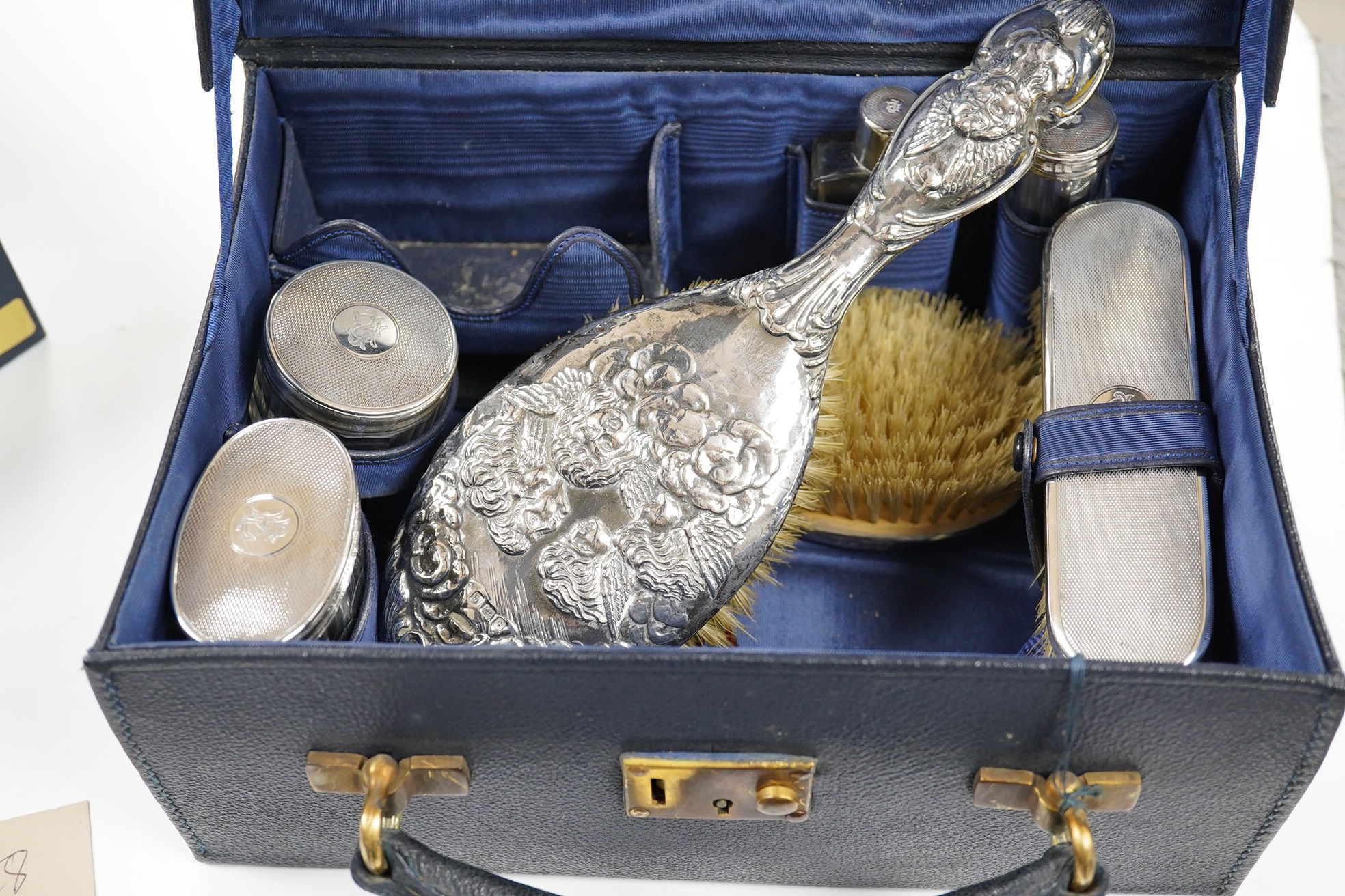 A small George V silver mounted travelling toilet set, various dates, patterns and makers. Condition - poor to fair